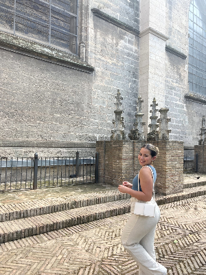 A girl posing in front of a building.